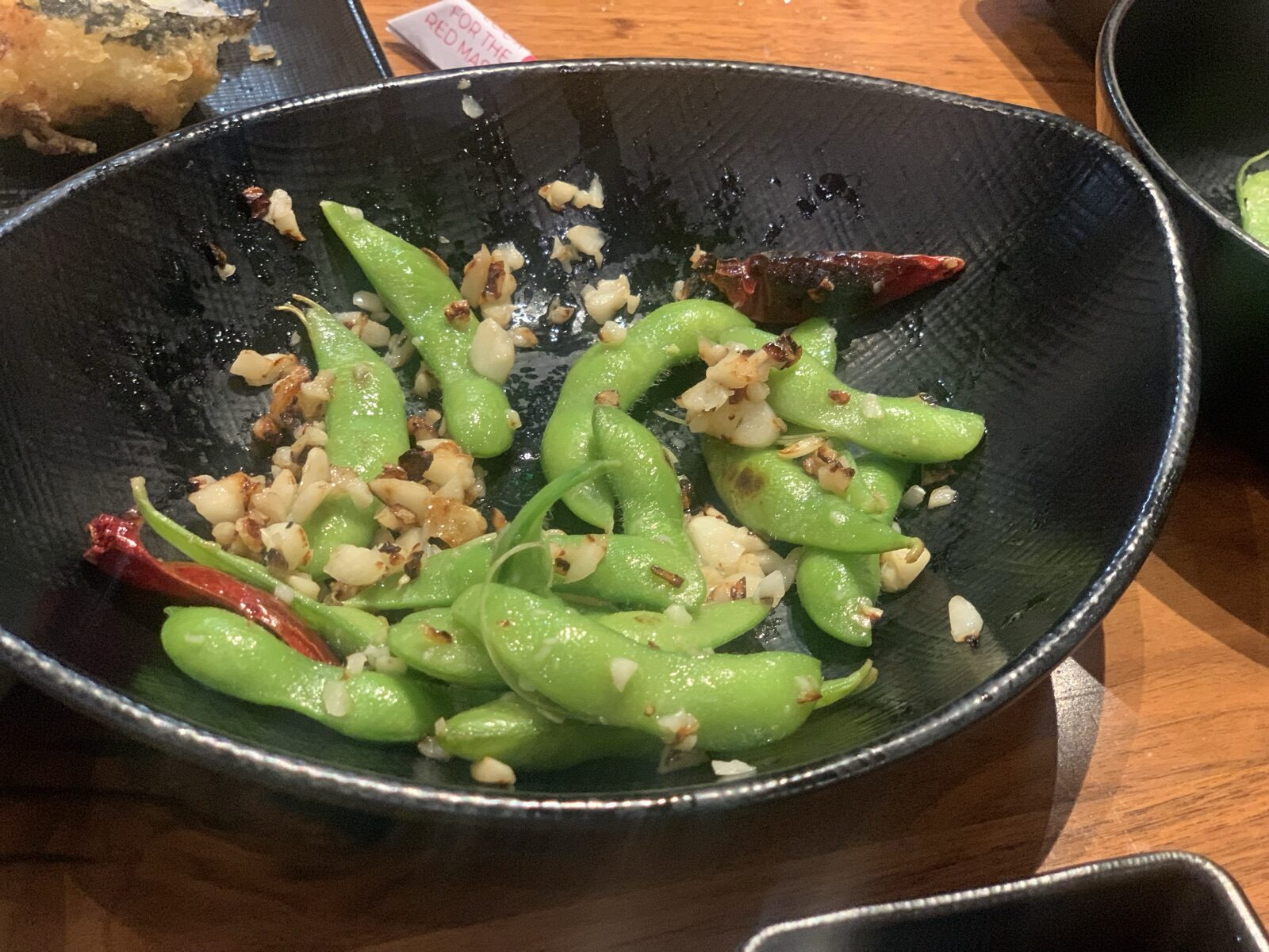 A bowl of garlic edamame with chili — whole soy foods deliver isoflavones that gut bacteria convert to equol, supporting hormonal balance