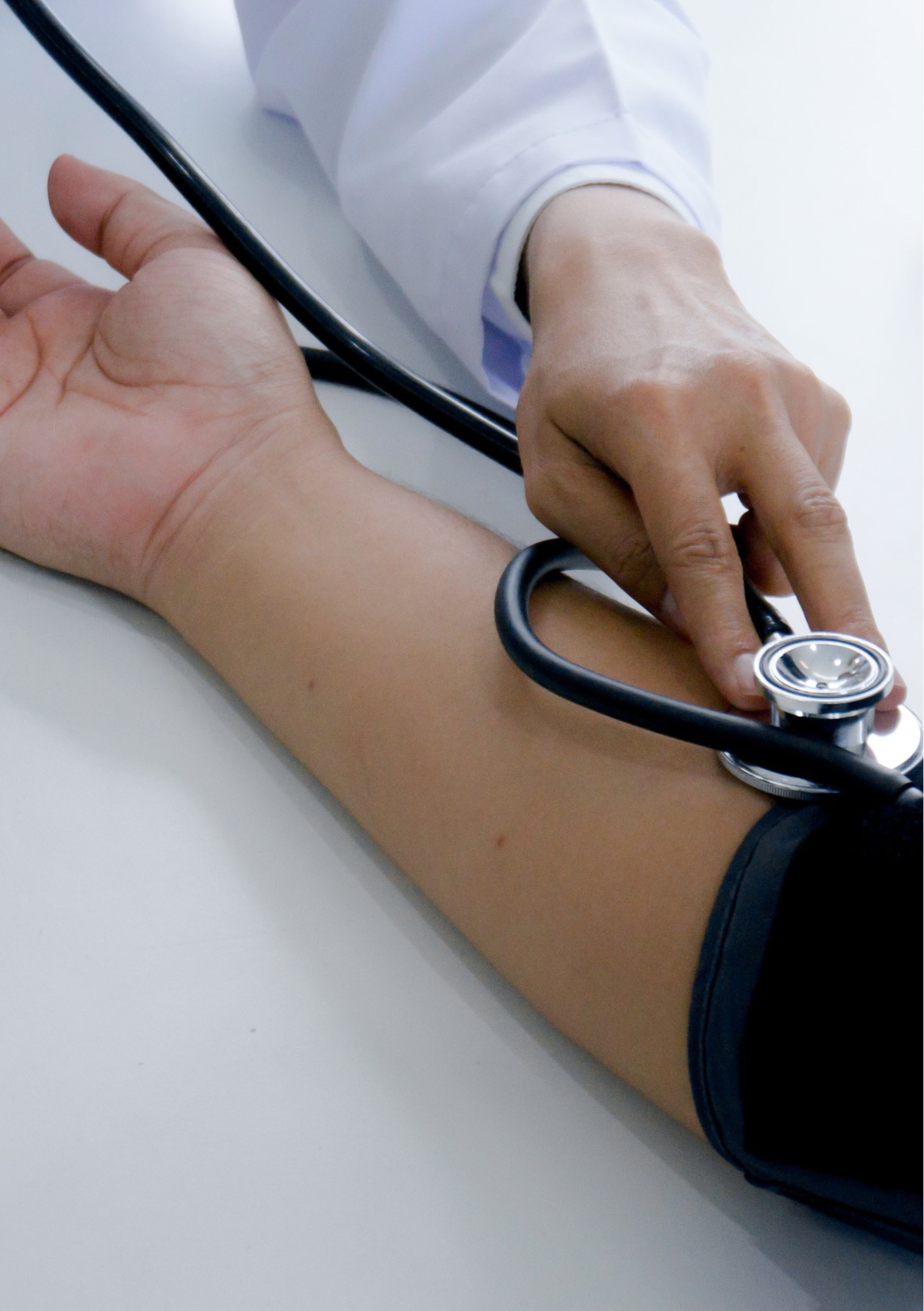 A clinician uses a stethoscope to measure a patient's blood pressure.